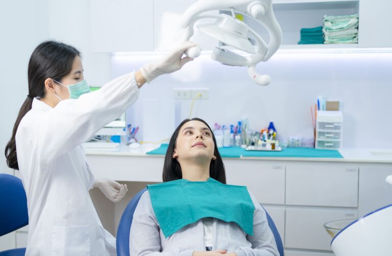asian female dentist adjust dental surgical light 2021 12 09 07 32 46 utc 2 1